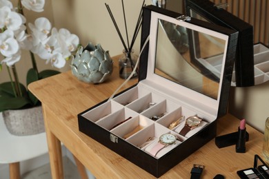 Elegant jewelry box with beautiful bijouterie, cosmetics and stylish accessories on dressing table in room