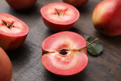 Photo of Tasty apples with red pulp on wooden table, closeup