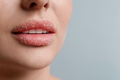 Photo of Closeup view of woman with lips covered in sugar on light grey background. Space for text