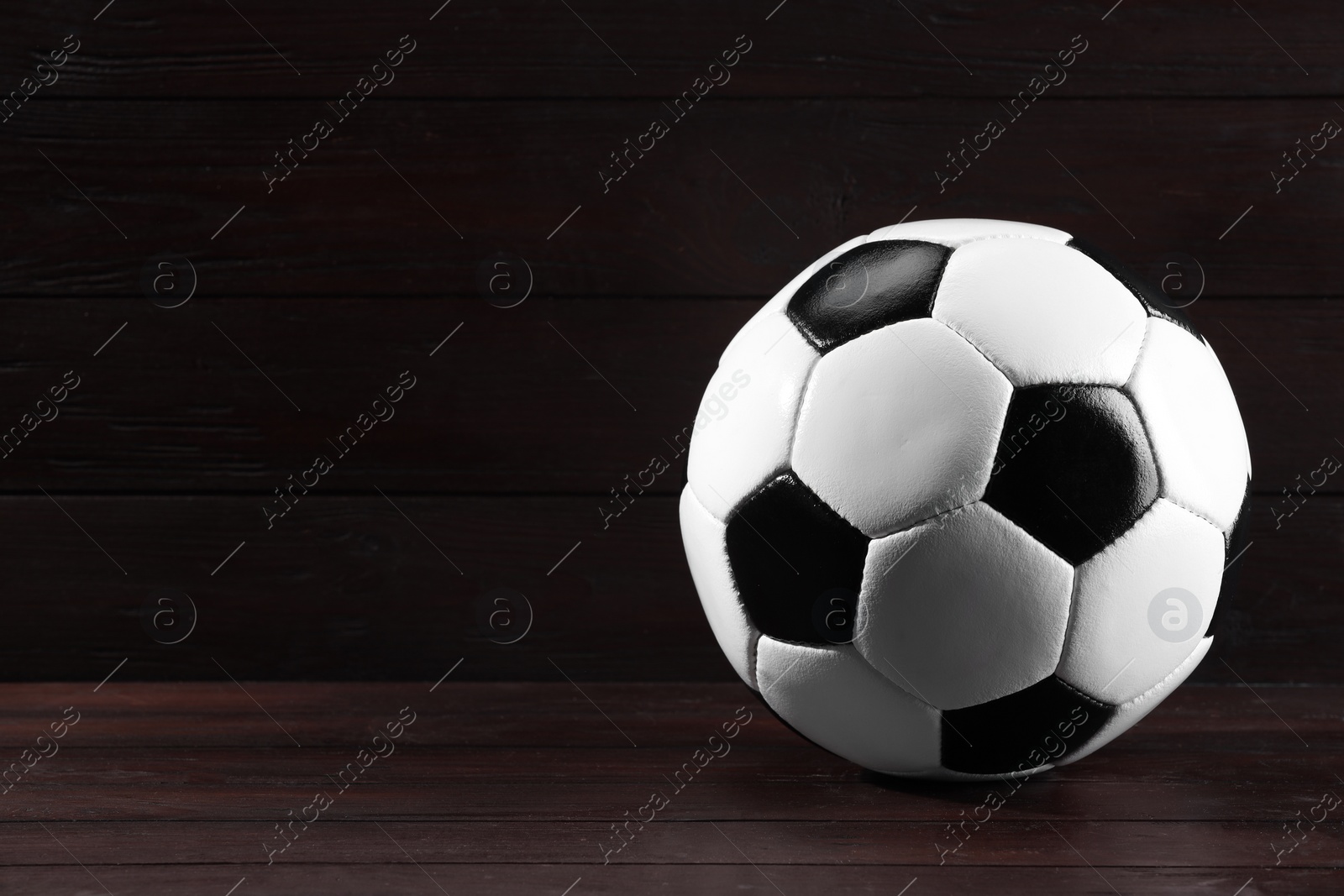 Photo of One soccer ball on wooden background, space for text