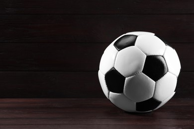 One soccer ball on wooden background, space for text