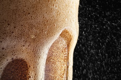 Photo of Glass of refreshing soda drink on black background, closeup