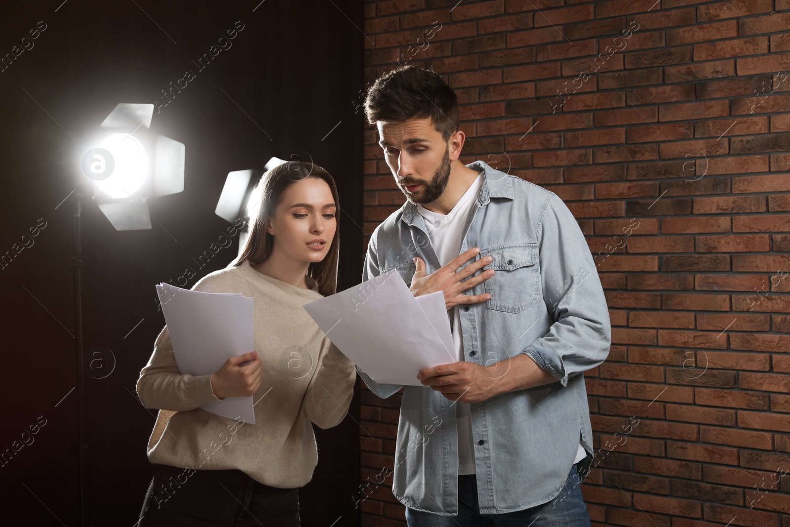 Photo of Professional actors reading their scripts during rehearsal in theatre