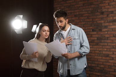 Photo of Professional actors reading their scripts during rehearsal in theatre