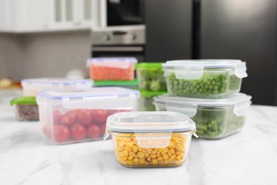 Photo of Containers with different fresh products on white marble table in kitchen. Food storage