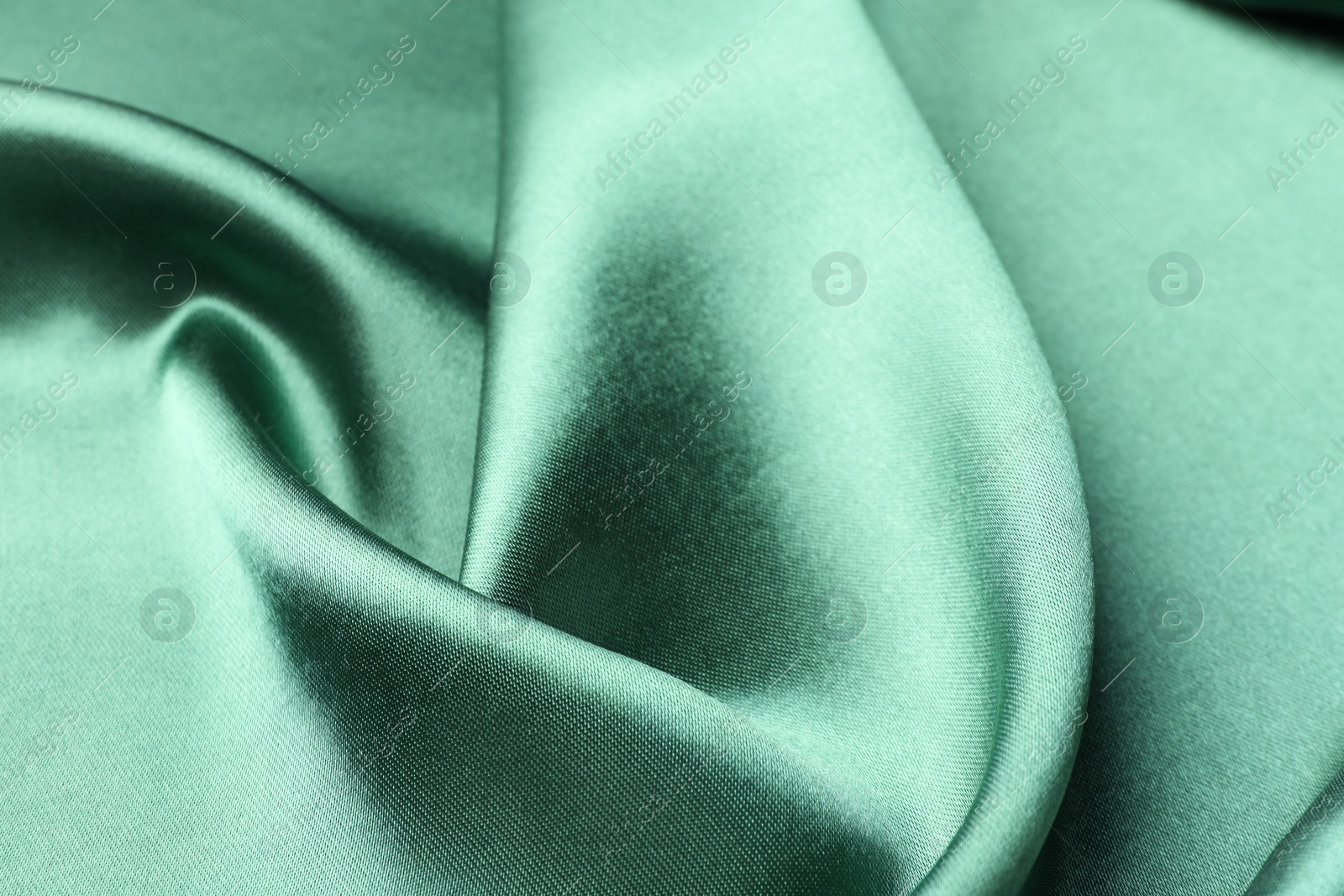 Photo of Crumpled green silk fabric as background, closeup