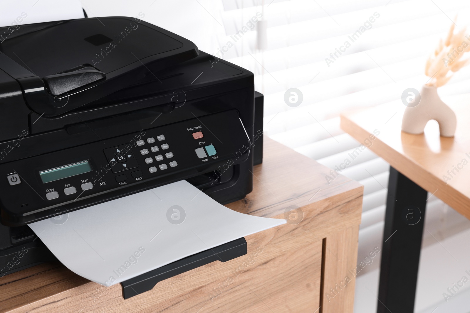 Photo of Modern printer with paper on wooden table indoors