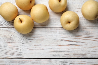 Photo of Ripe apple pears on white wooden table, flat lay. Space for text
