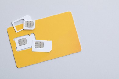 Modern SIM cards on light grey background, flat lay