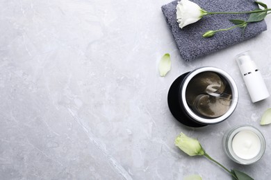 Flat lay composition with under eye patches on light grey marble table, space for text. Cosmetic product