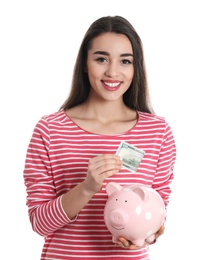 Photo of Portrait of happy young woman with money and piggy bank on white background