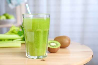Photo of Glass of fresh celery juice on wooden table, closeup