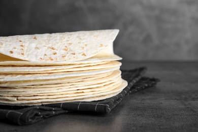 Photo of Stack of corn tortillas on table, closeup with space for text. Unleavened bread