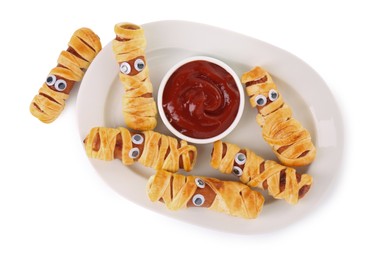 Plate with tasty sausage mummies for Halloween party and ketchup isolated on white, top view