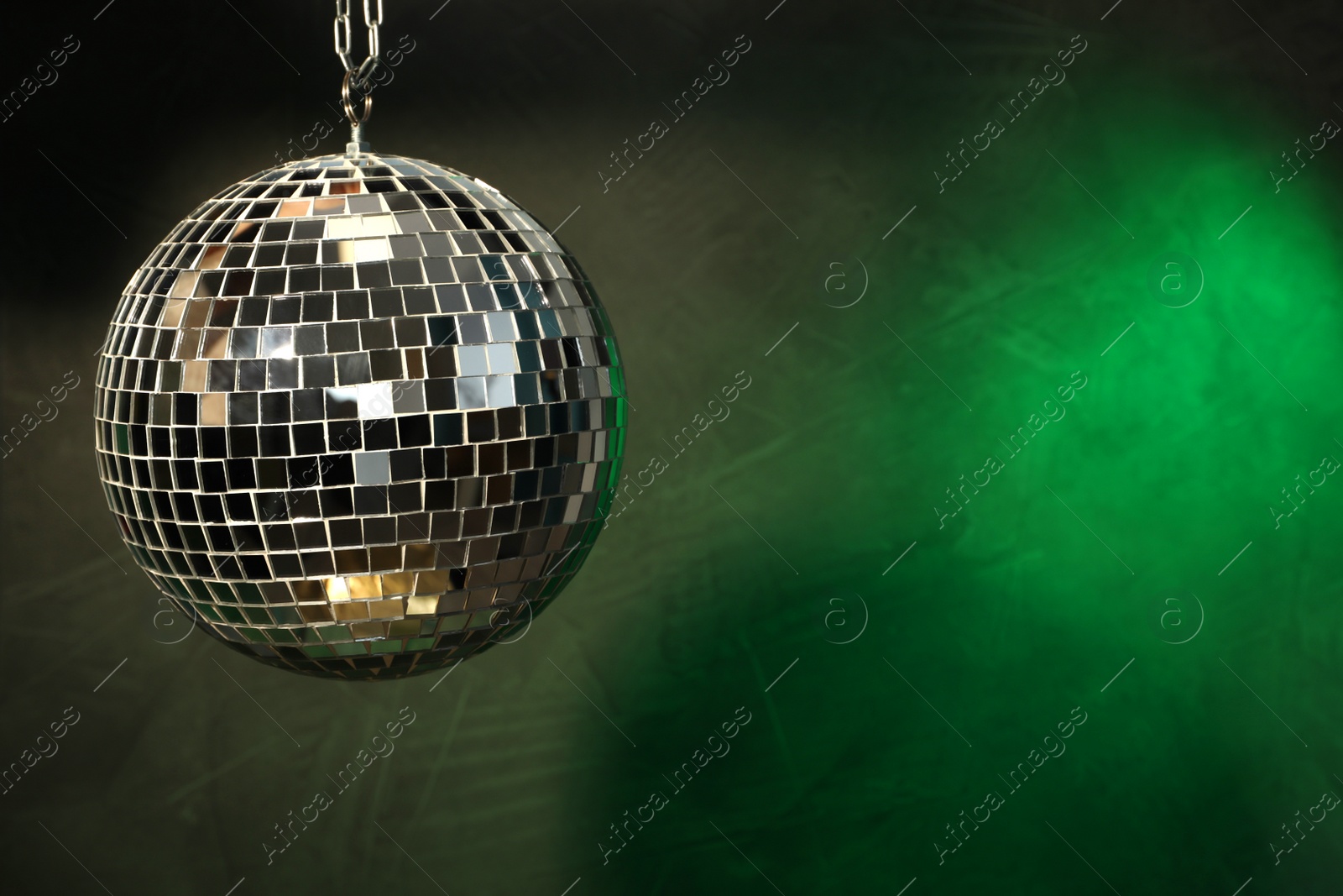 Photo of Shiny disco ball on dark background. Space for text