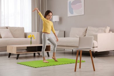 Cute little girl taking online dance class at home