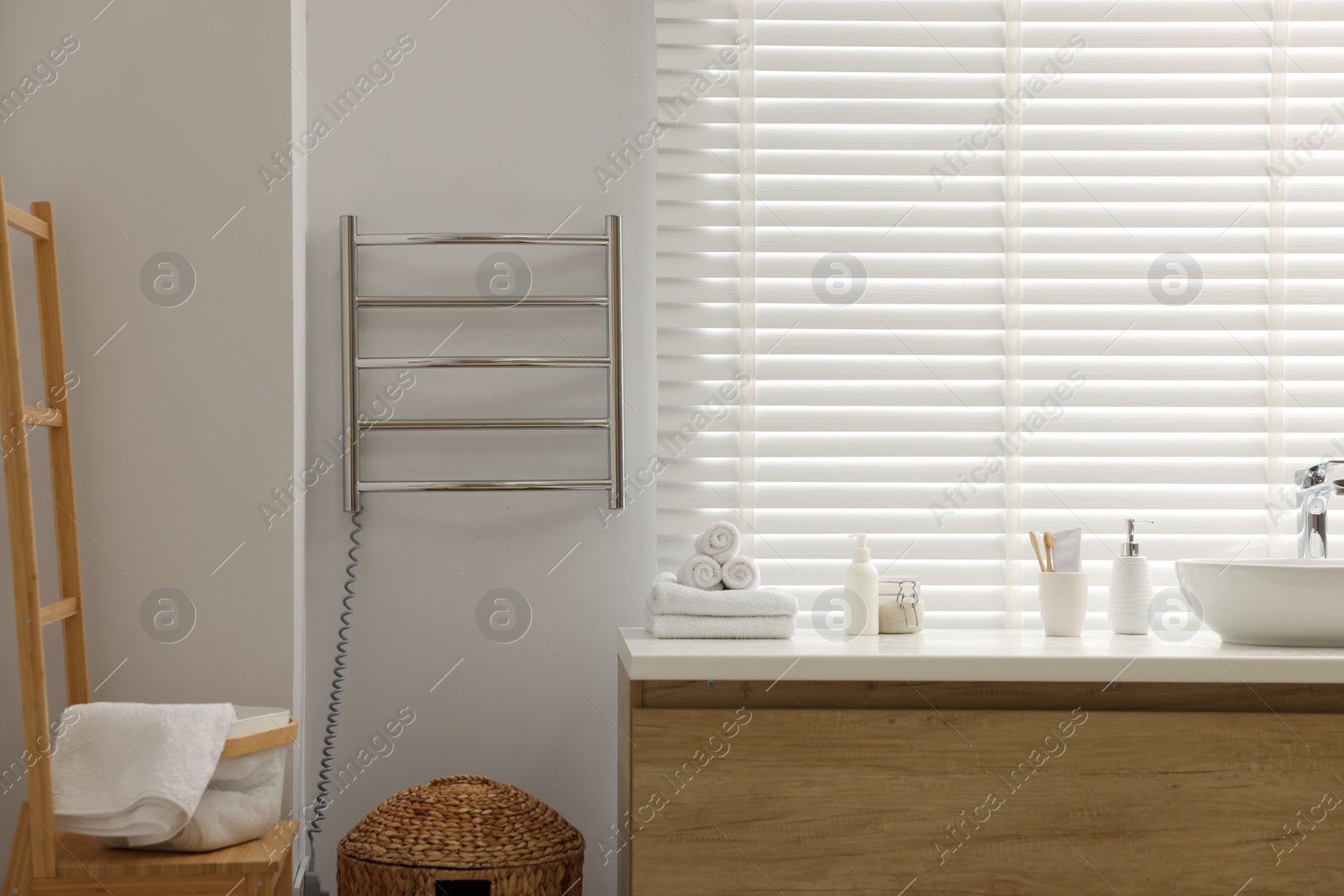 Photo of Stylish bathroom interior with heated towel rail and vanity