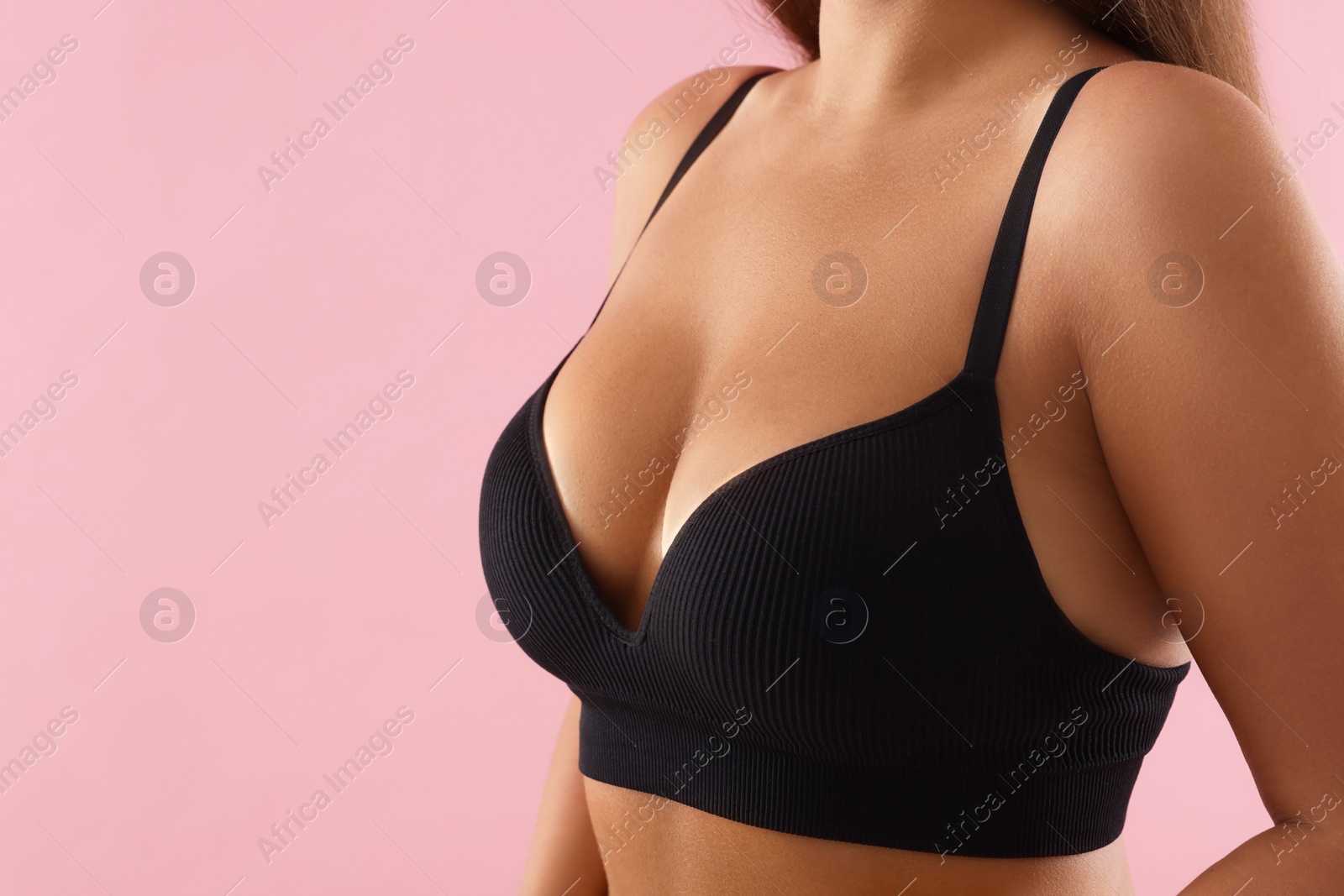 Photo of Woman with beautiful breast on pink background, closeup. Space for text