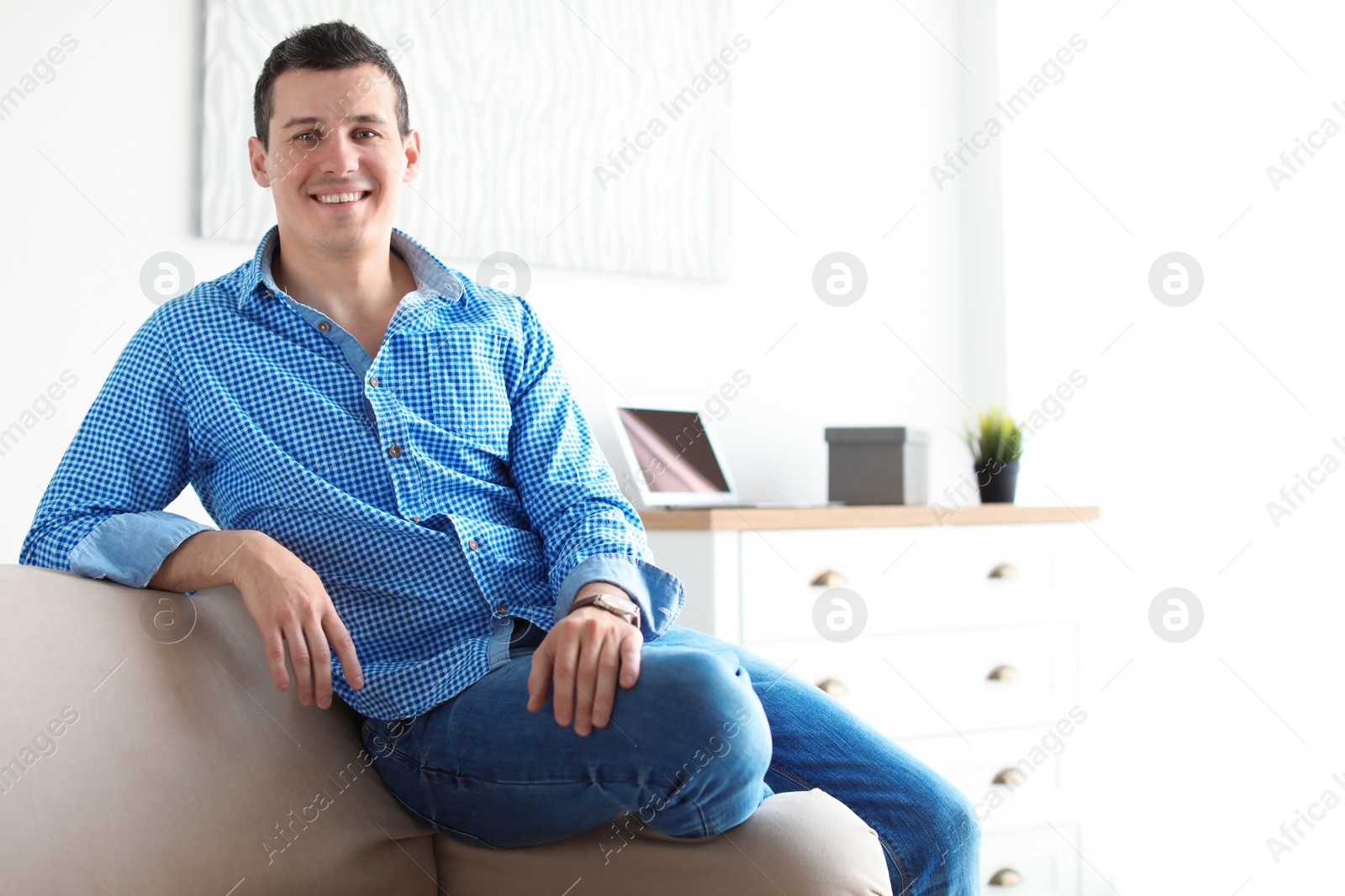 Photo of Portrait of confident man on sofa at home