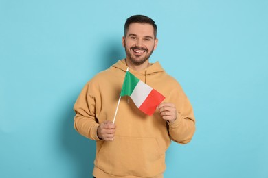 Photo of Man with flag of Italy on light blue background
