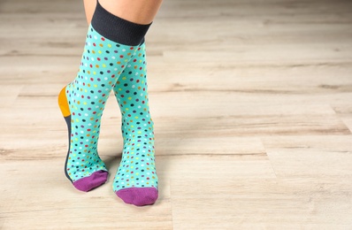 Woman wearing stylish socks standing on floor. Space for design