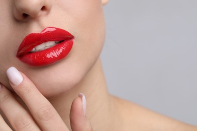 Young woman with perfect lips makeup on light background, closeup. Space for text