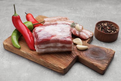 Tasty pork fatback with spices on grey table, closeup