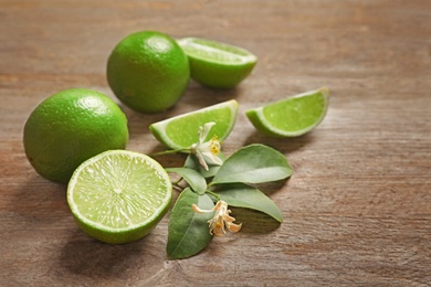 Photo of Fresh ripe limes on wooden table. Citrus fruit