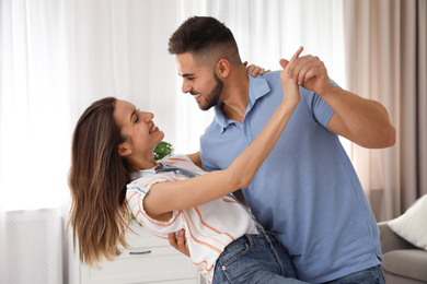 Photo of Lovely young couple dancing in kitchen at home