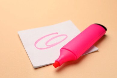 Photo of Bright pink marker and sticky note on beige background, closeup