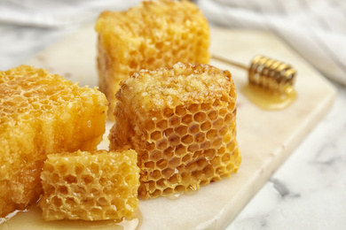 Photo of Fresh delicious honeycombs on white board, closeup
