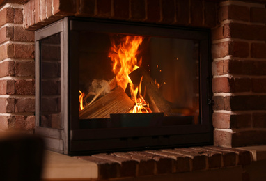 Photo of Fireplace with burning wood indoors. Winter vacation