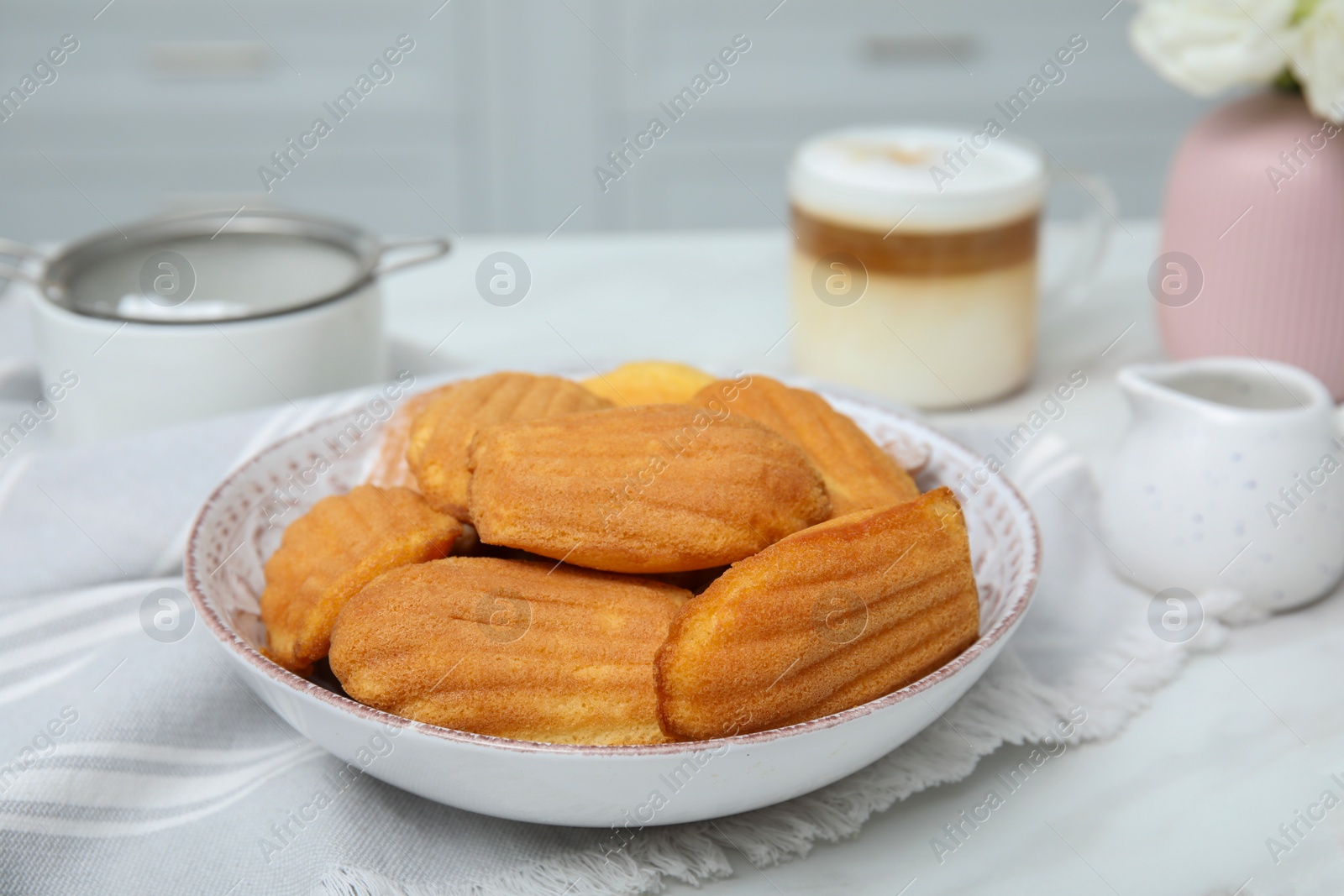 Photo of Tasty madeleine cookies on table in kitchen