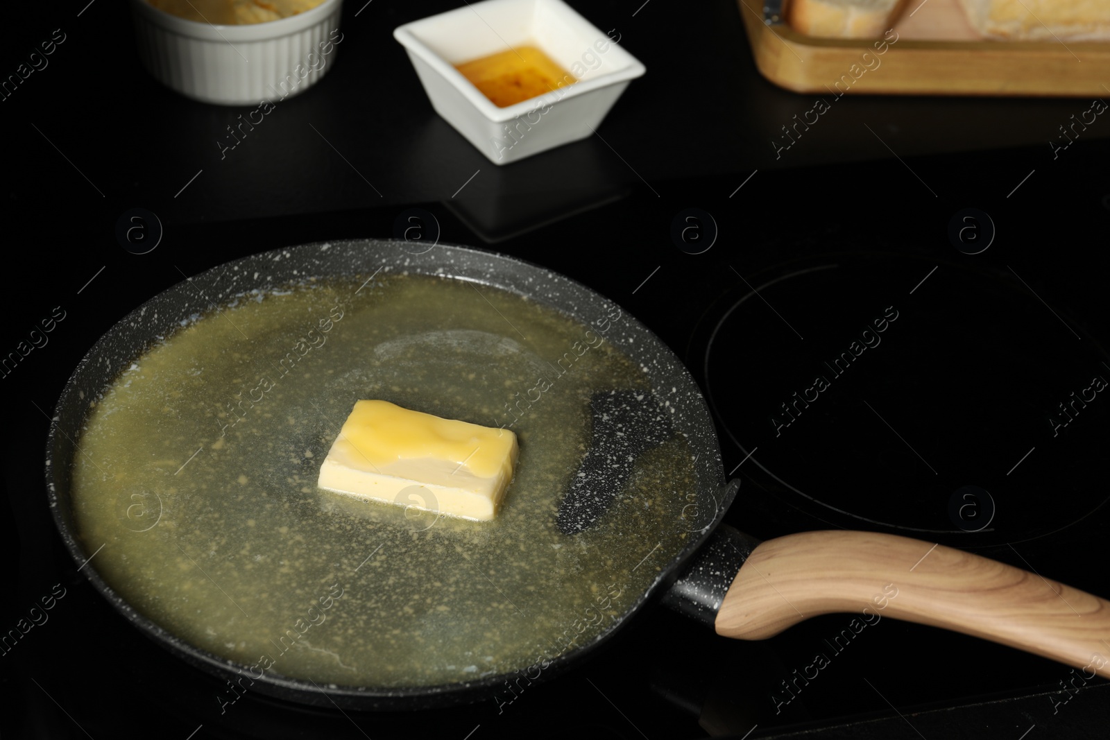 Photo of Melting butter in frying pan on cooktop