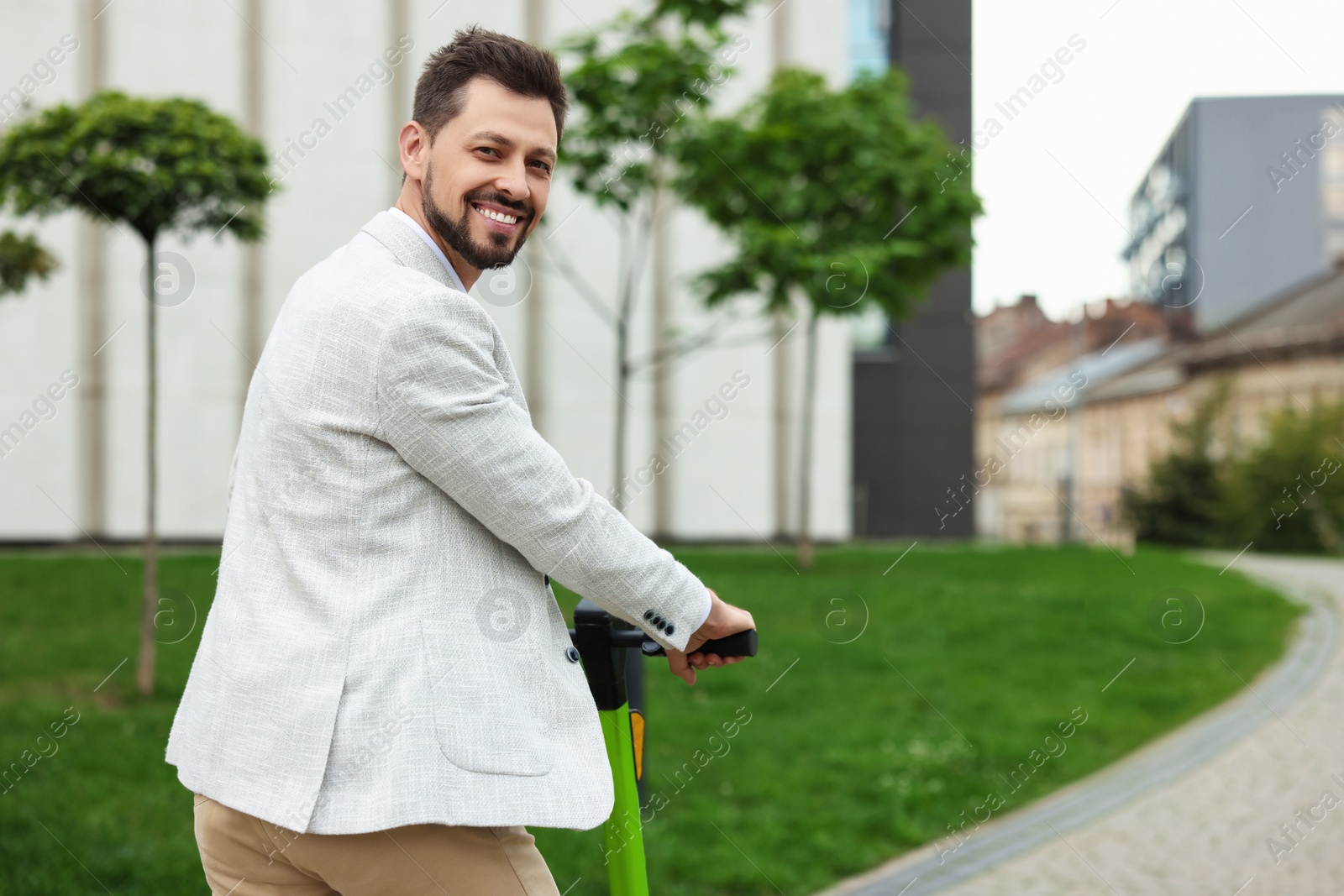 Photo of Businessman with modern kick scooter on city street, space for text