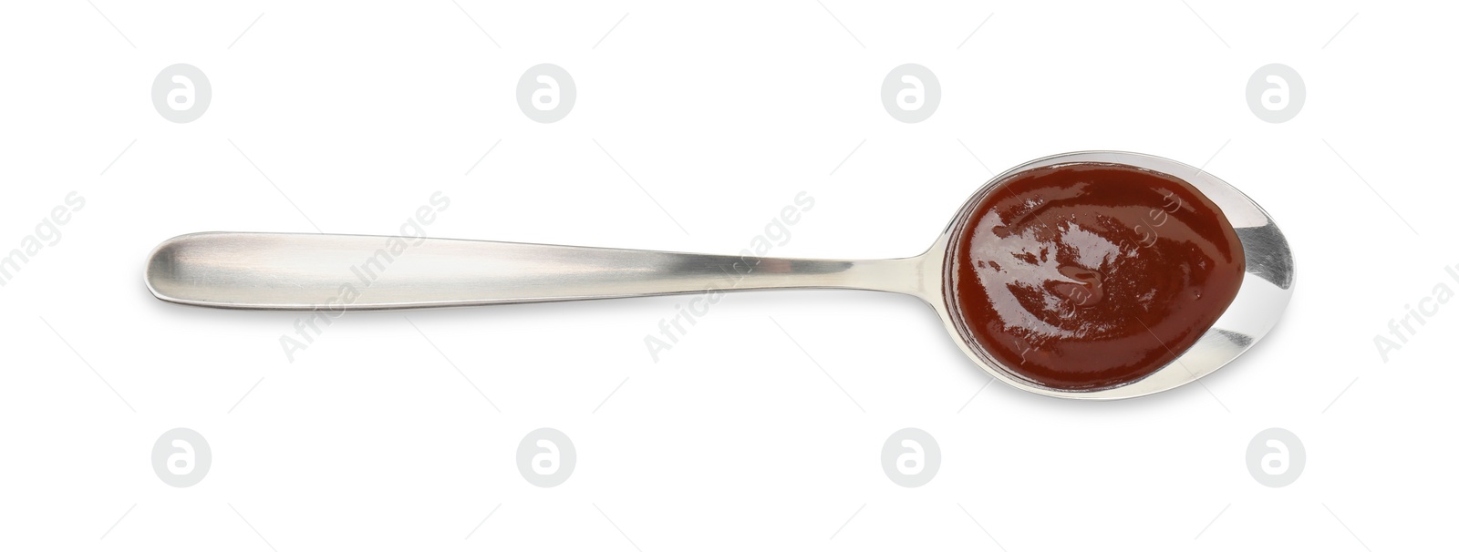 Photo of Tasty barbecue sauce in spoon isolated on white, top view