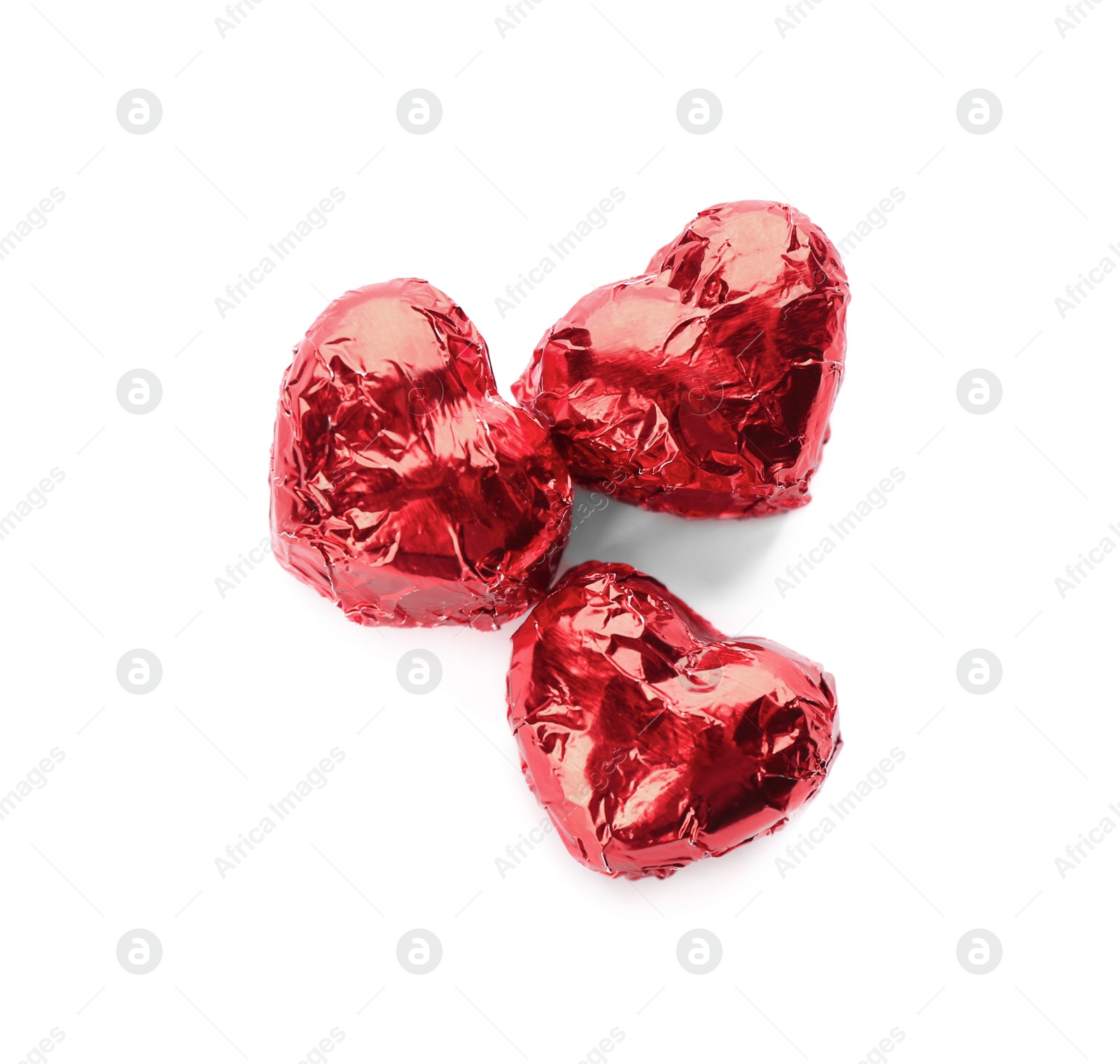 Photo of Heart shaped chocolate candies in red foil on white background, top view