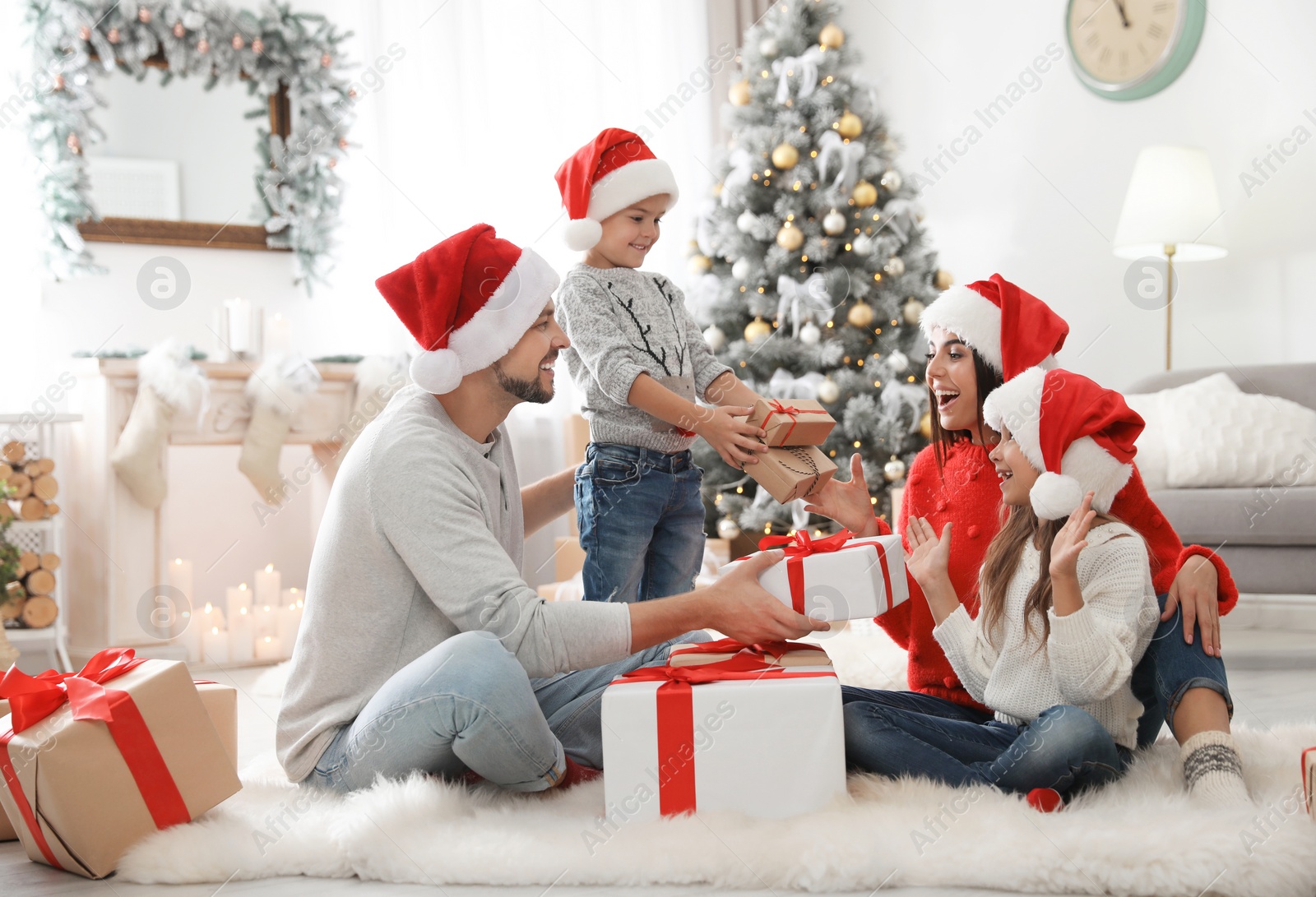 Photo of Happy family with children and Christmas gifts on floor at home