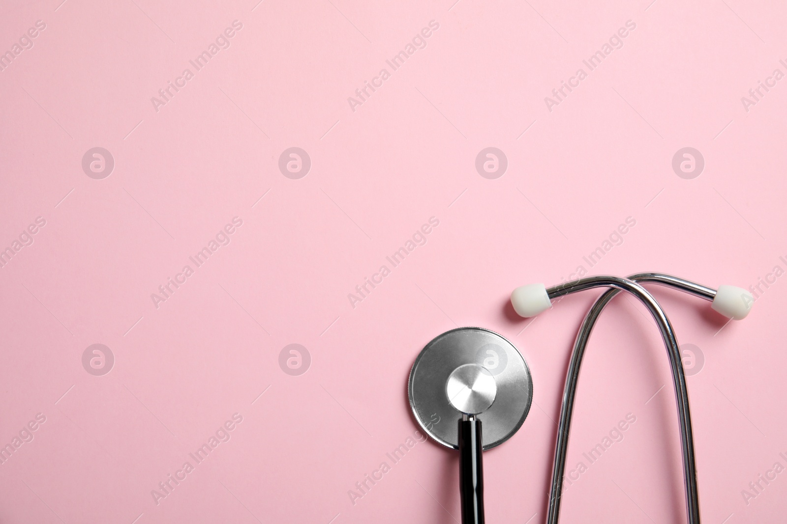 Photo of Stethoscope with space for text on color background, top view. Medical tool
