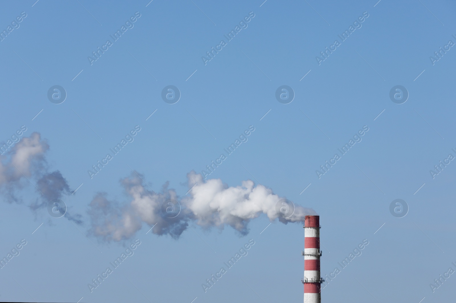 Photo of Polluting air with smoke from industrial chimney outdoors, space for text. CO2 emissions