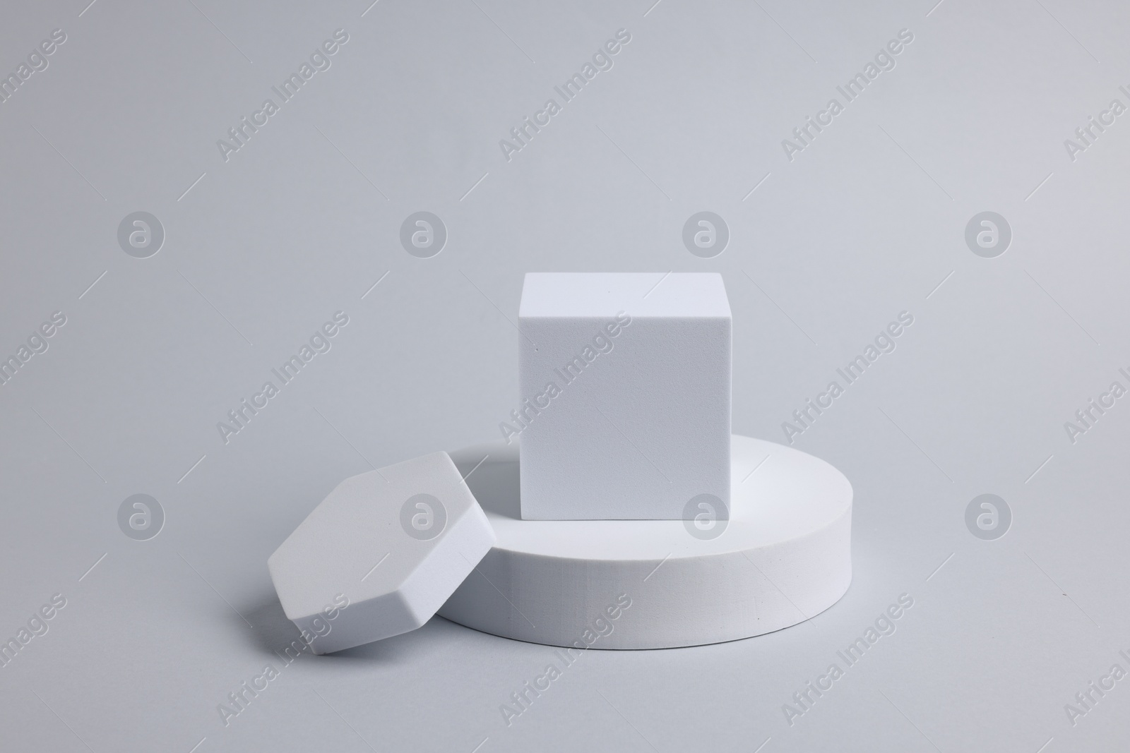 Photo of Scene with podium for product presentation. Figures of different geometric shapes on light grey background