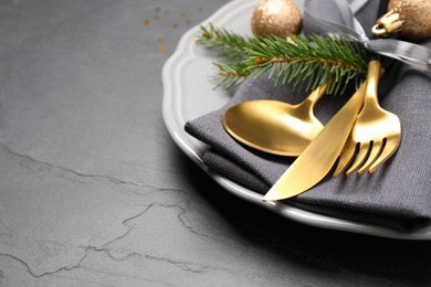 Festive table setting with beautiful dishware and Christmas decor on black background, closeup. Space for text