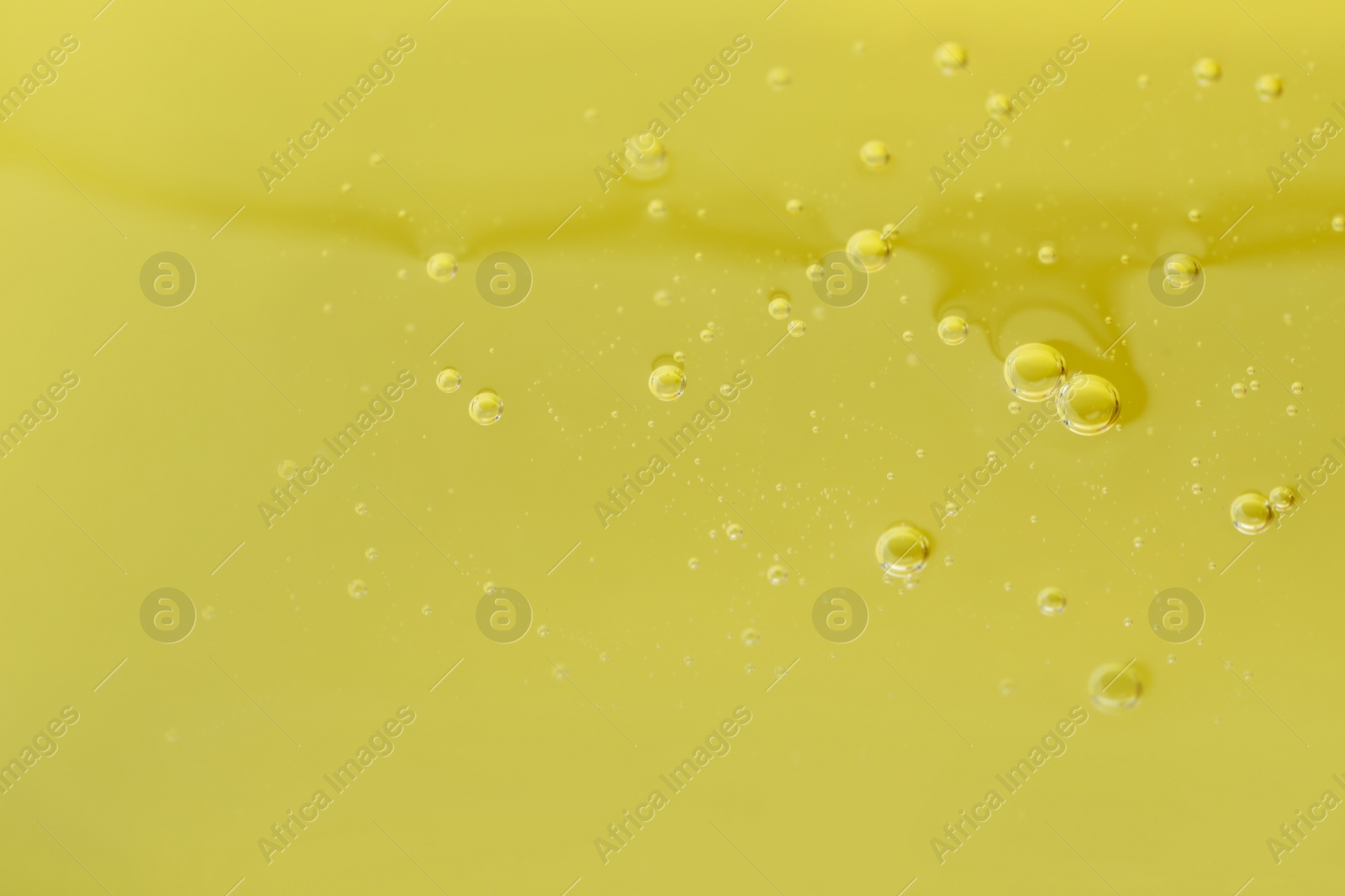 Photo of Pure transparent cosmetic gel on yellow background, closeup