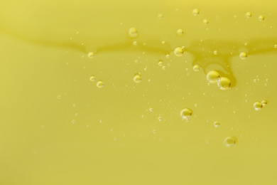 Photo of Pure transparent cosmetic gel on yellow background, closeup