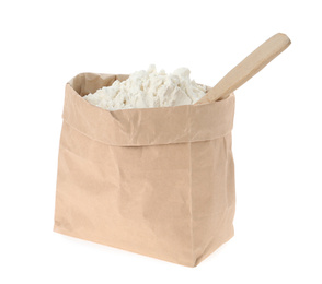 Photo of Organic flour and spoon in paper bag isolated on white