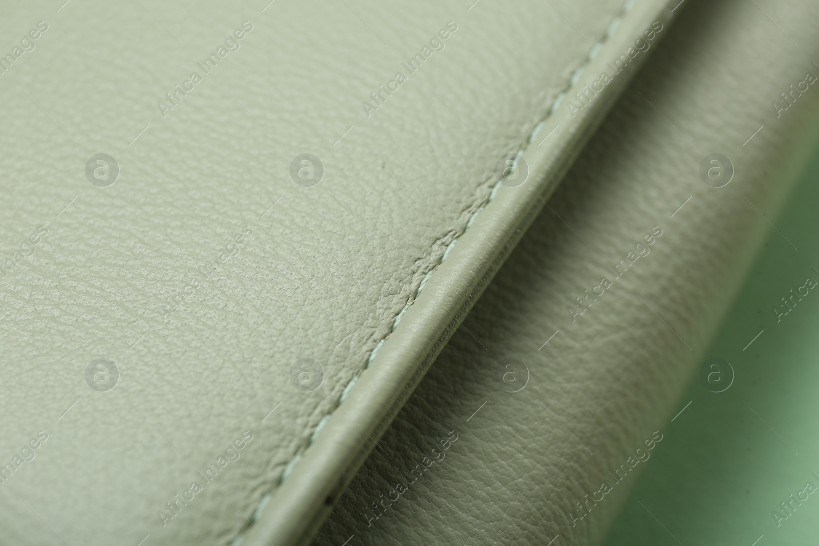 Photo of Green leather with seam on table, closeup