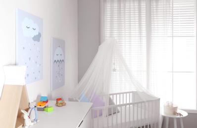 Baby room interior with cute posters and comfortable crib