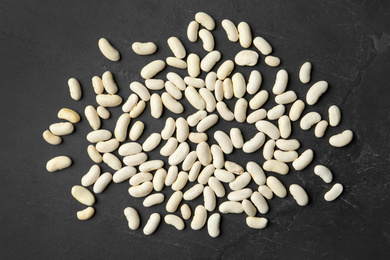 Raw beans on black background, flat lay. Vegetable seeds