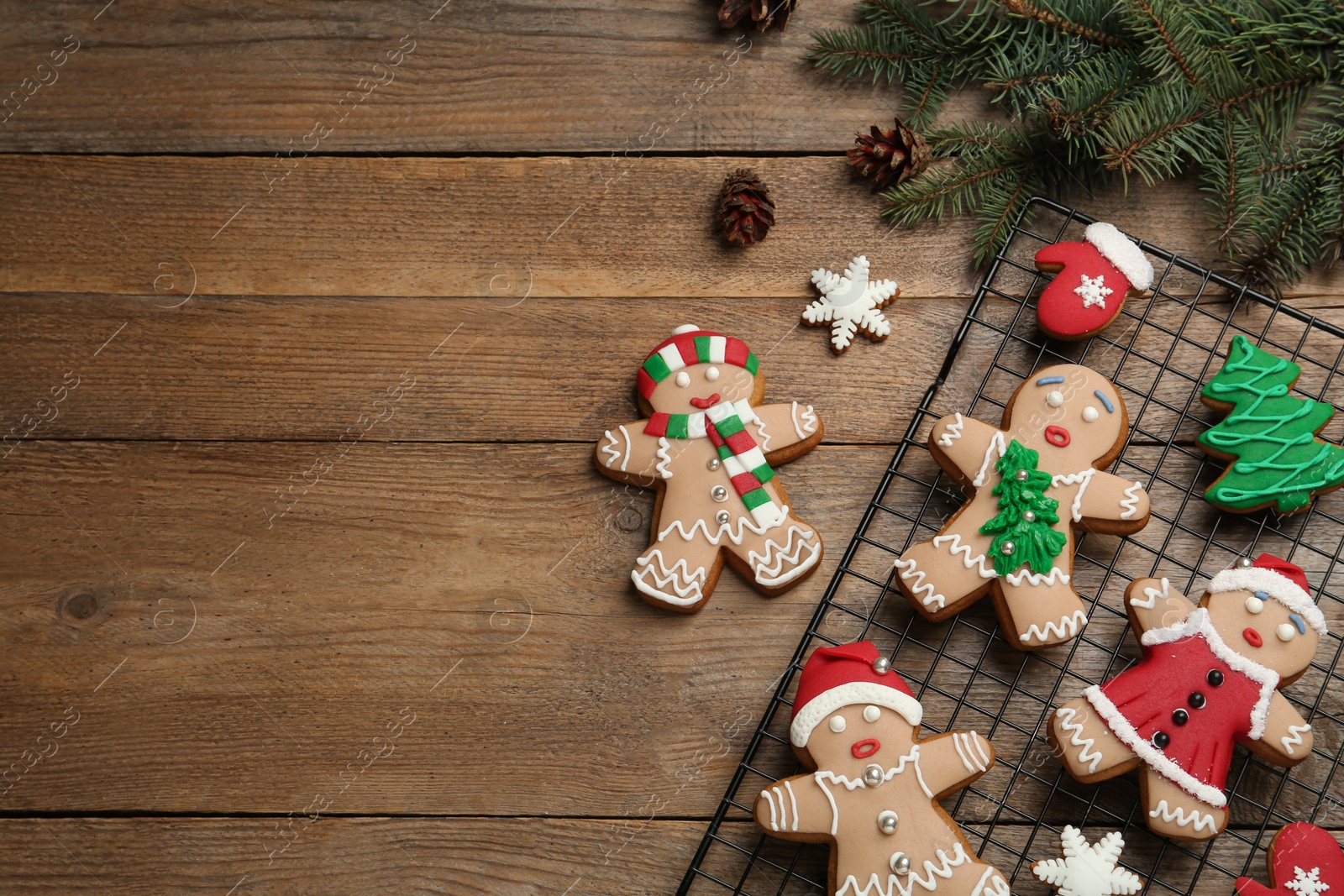 Photo of Delicious Christmas cookies and fir branches on wooden table, flat lay. Space for text