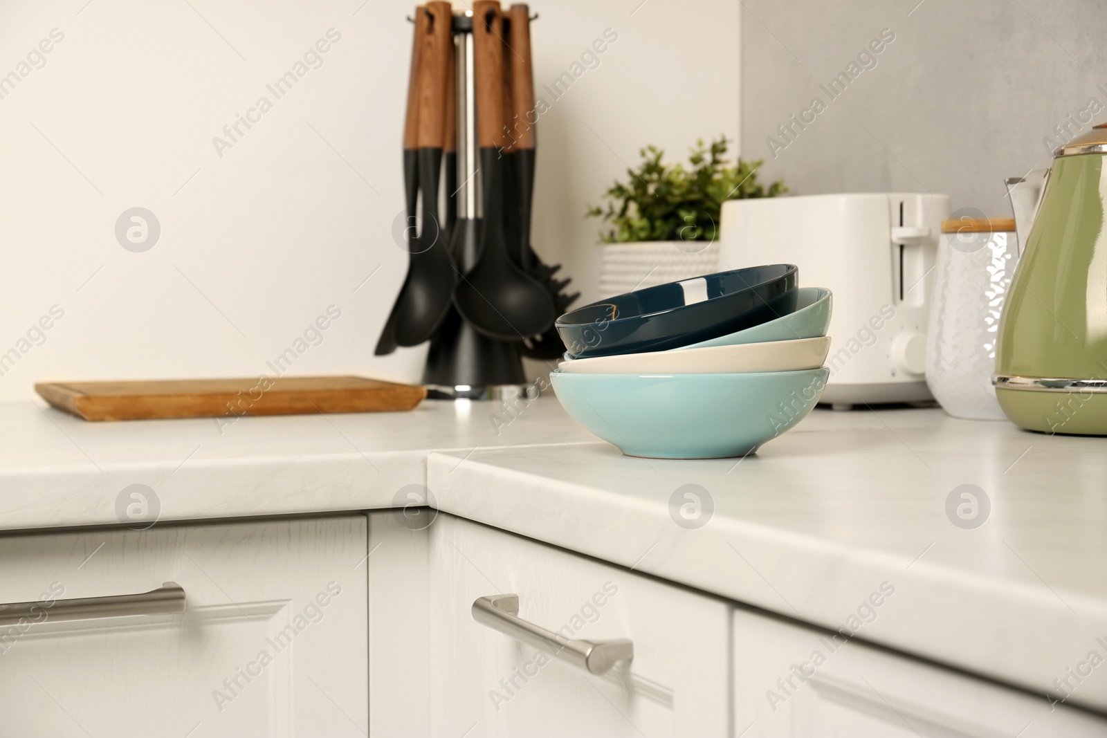 Photo of Set of clean color bowls on white countertop in kitchen